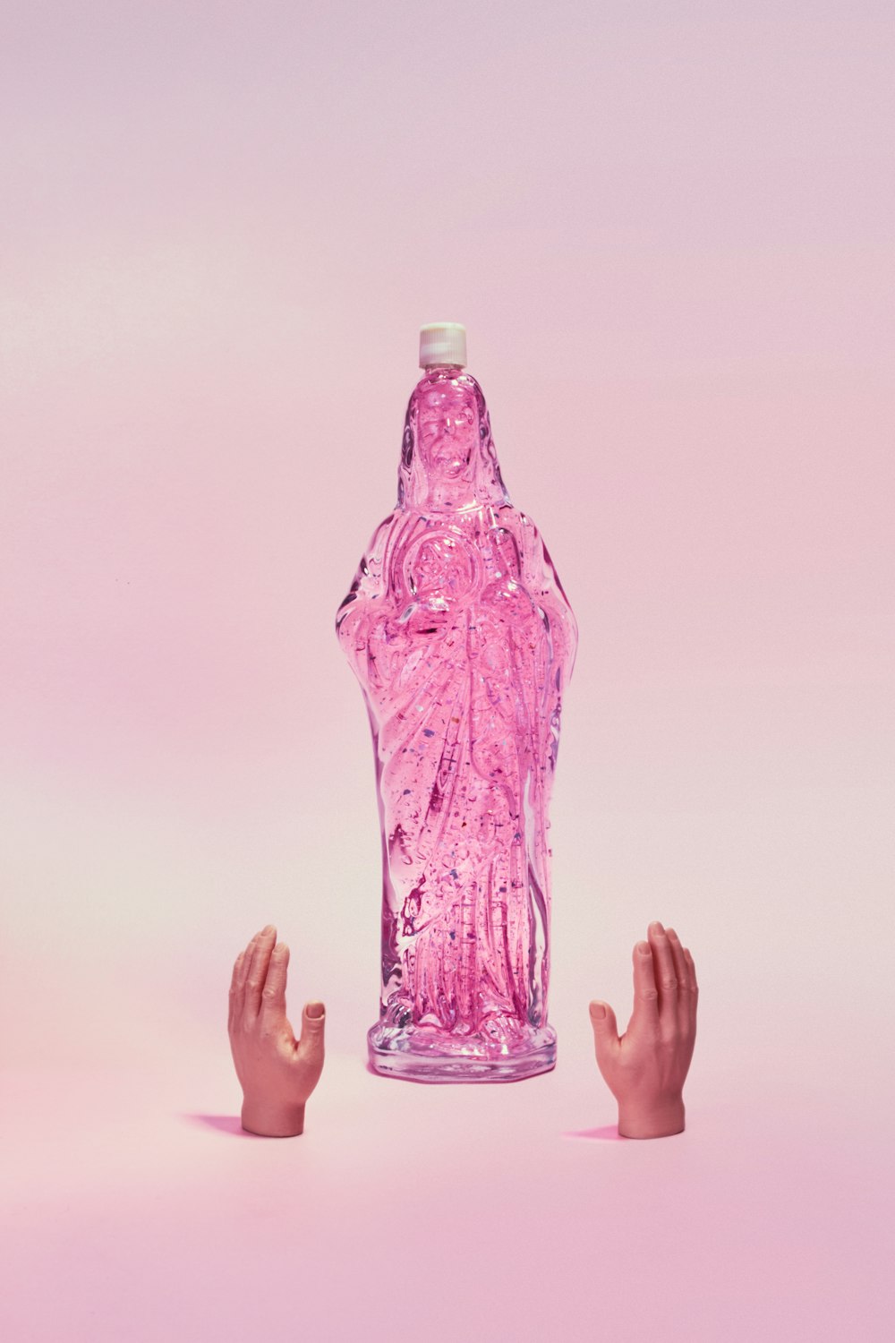 Persona che tiene in mano una bottiglia di plastica viola
