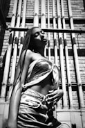 Stylish individual posing confidently against an industrial backdrop.