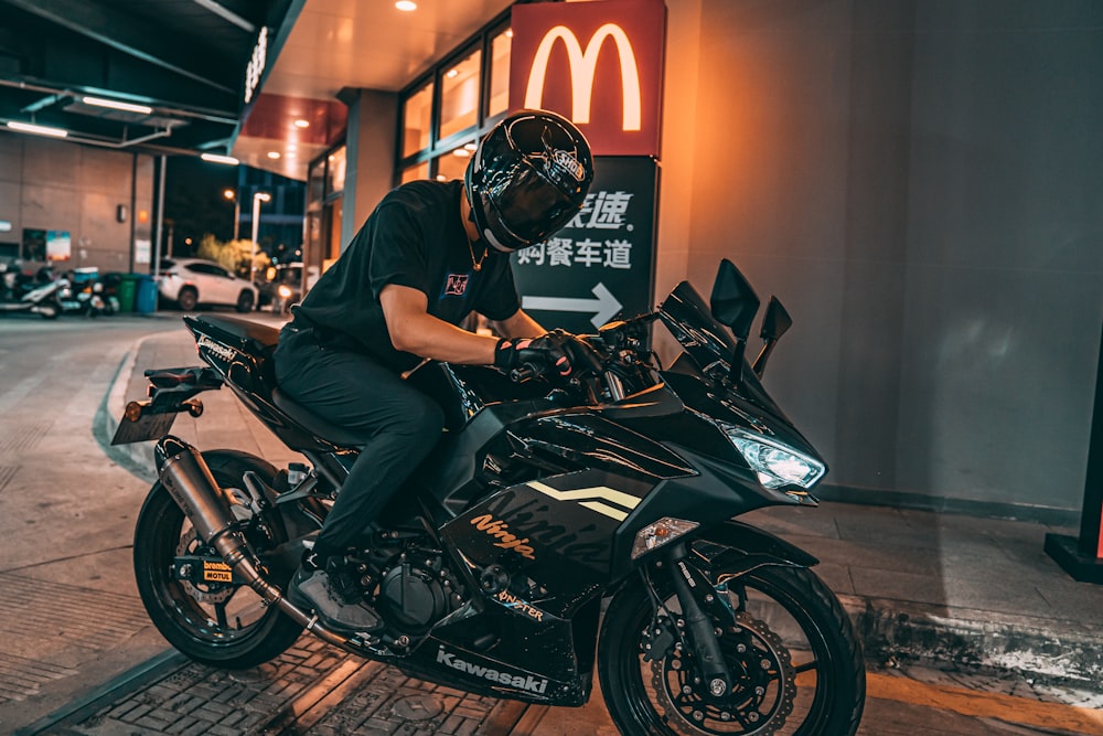 man in black t-shirt riding black motorcycle