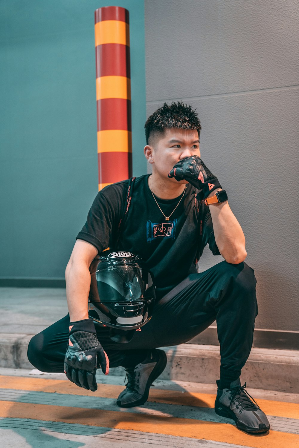 man in black crew neck t-shirt and black pants sitting on black skateboard