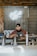 man in black and red crew neck t-shirt wearing black cap sitting on stainless steel