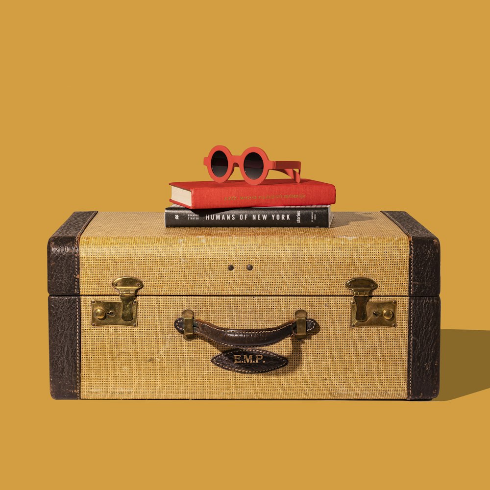 brown and black suitcase with red and yellow plastic toy