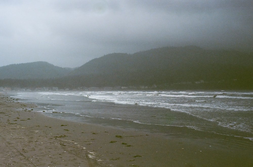 sea waves crashing on shore during daytime