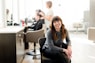 woman in gray long sleeve shirt and black pants sitting on black chair