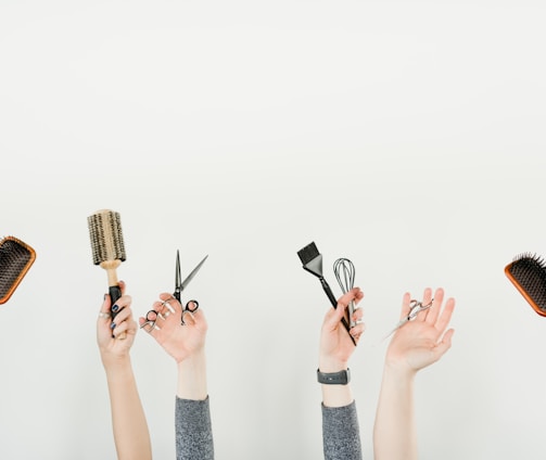 person holding silver and black hair brush