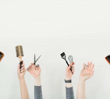 person holding silver and black hair brush