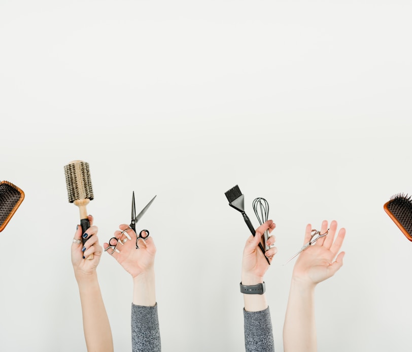 person holding silver and black hair brush