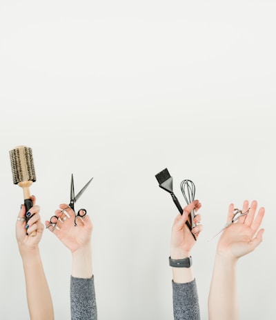 person holding silver and black hair brush