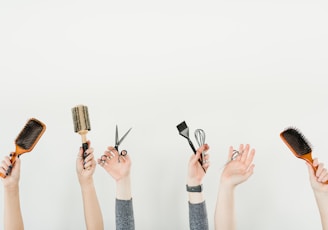 person holding silver and black hair brush