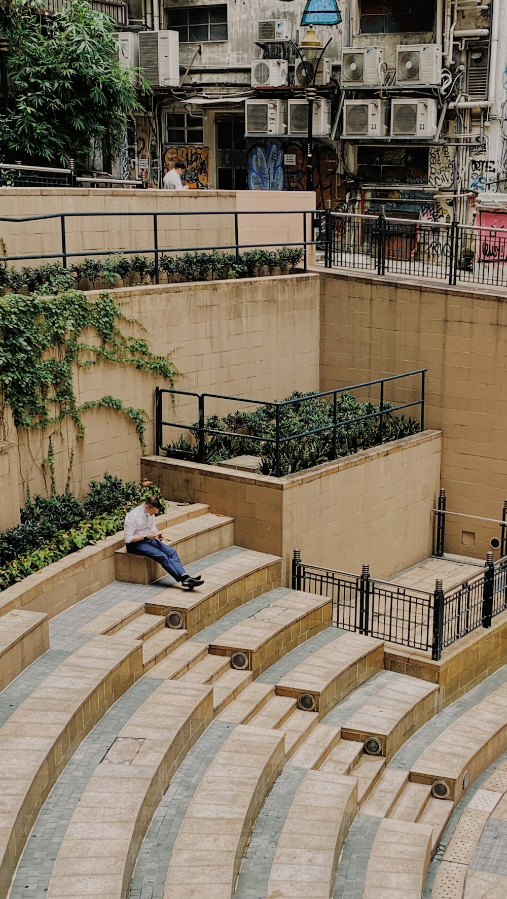 man in blue denim jeans sitting on brown concrete bench during daytime