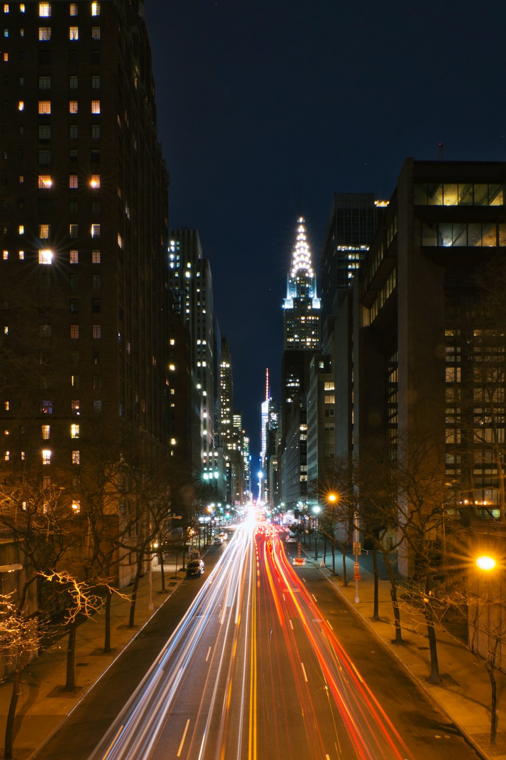 auto sulla strada tra grattacieli durante la notte