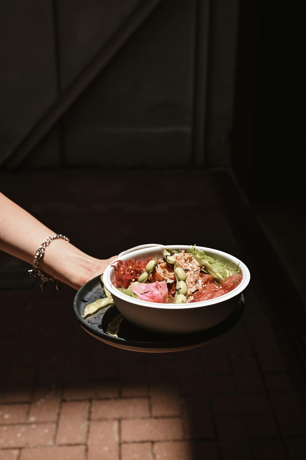 person holding white ceramic bowl with food