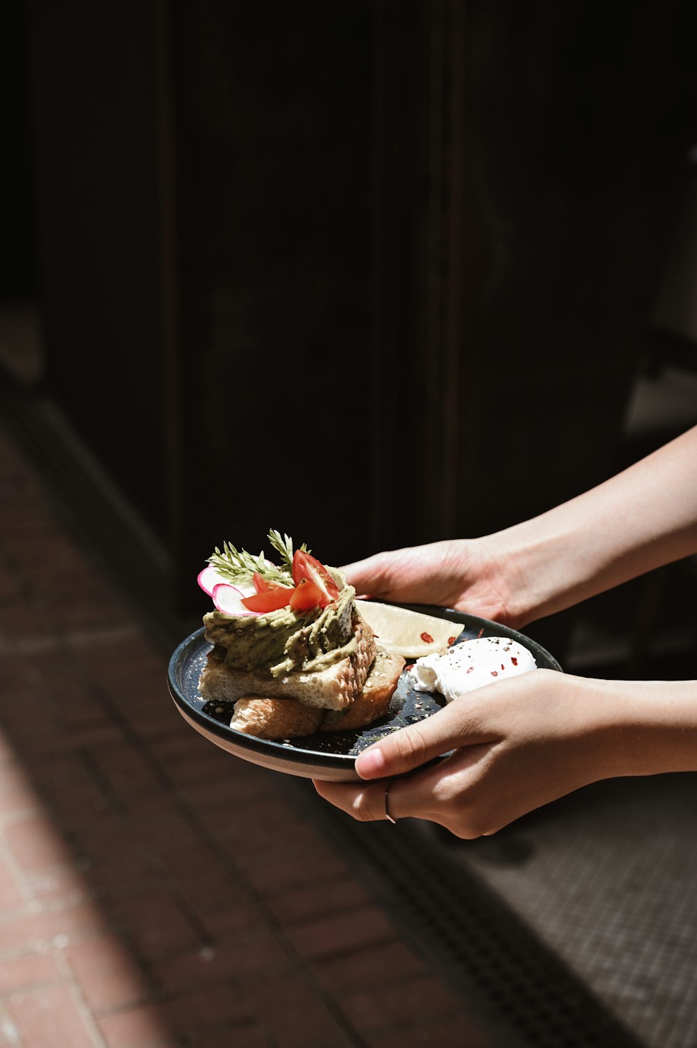 person holding a white ceramic bowl with food