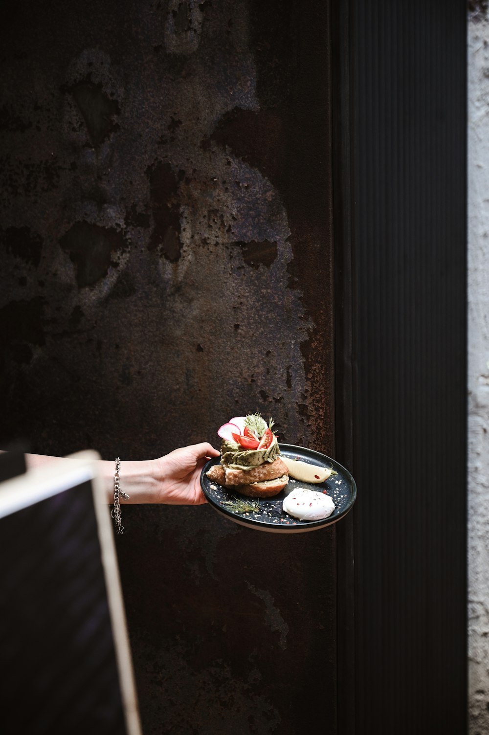 person holding a blue ceramic plate with food