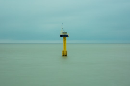 yellow and white tower on the middle of the sea in Cadzand Netherlands