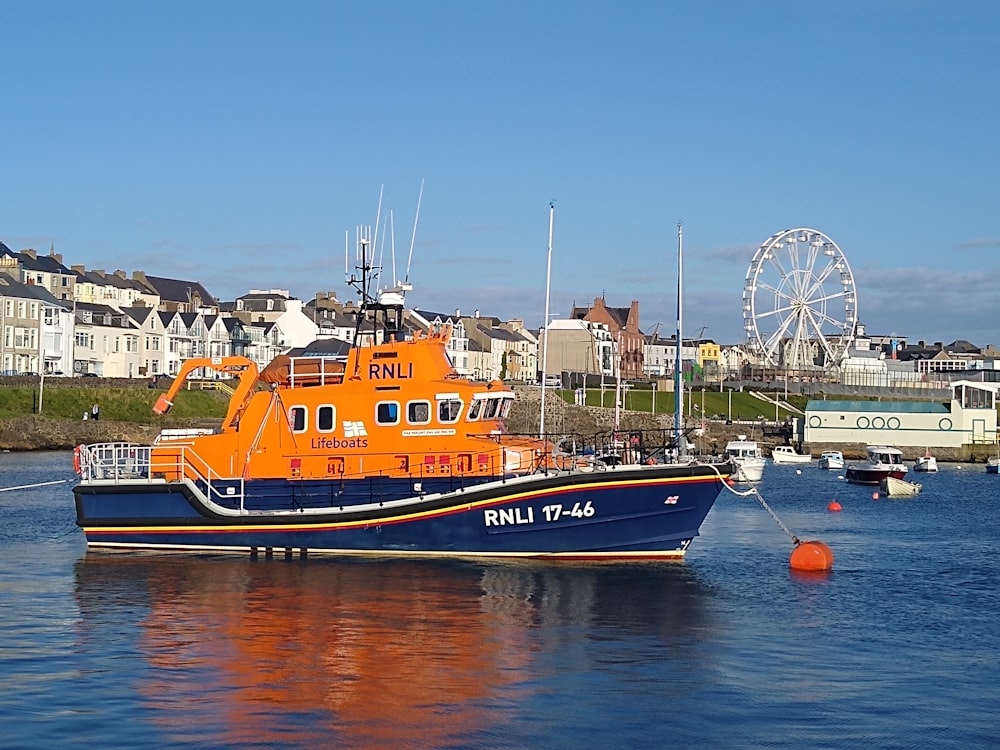 orange and black boat on water during daytime