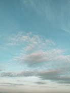 A serene blue sky with gentle clouds at dawn, symbolizing peaceful inspiration.