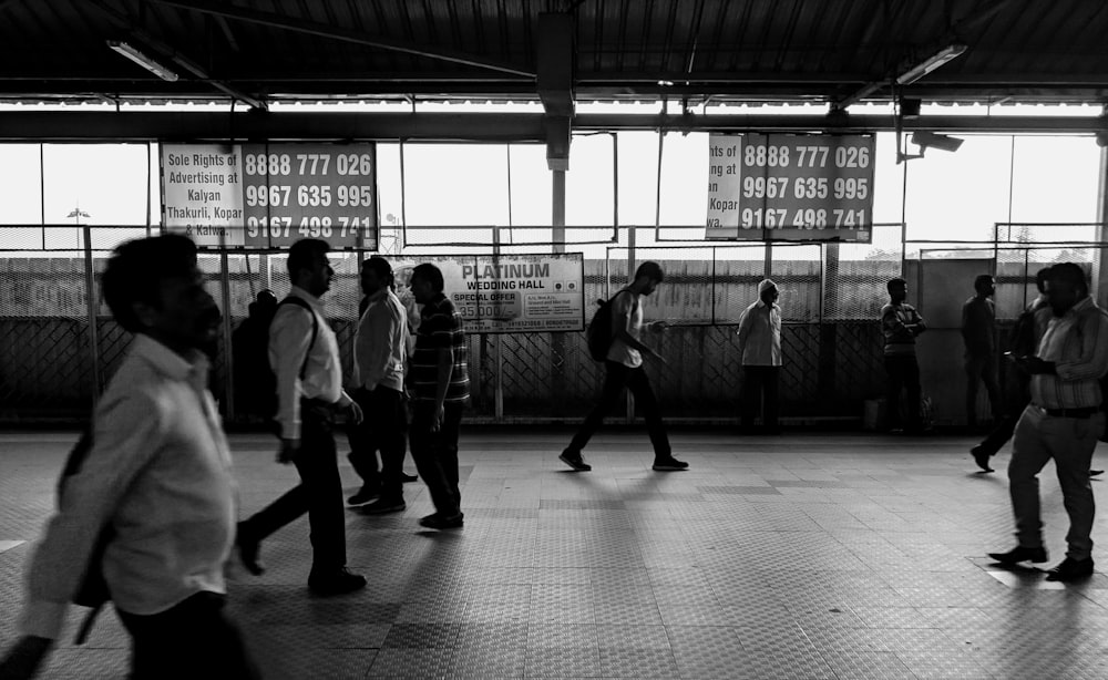 grayscale photo of people walking on sidewalk