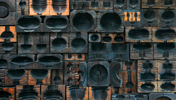 Stacked wooden blocks featuring traditional African patterns and symbols in earthy tones.