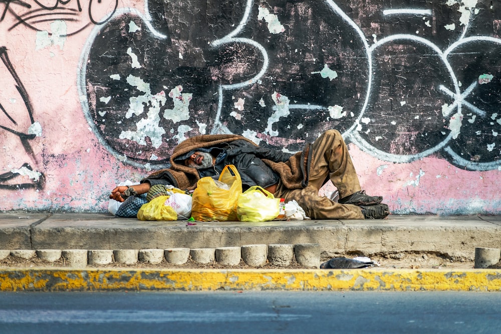 콘크리트 바닥에 누워 있는 노란 재킷을 입은 남자
