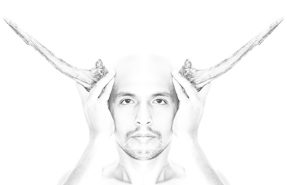 grayscale photo of man with right hand on head