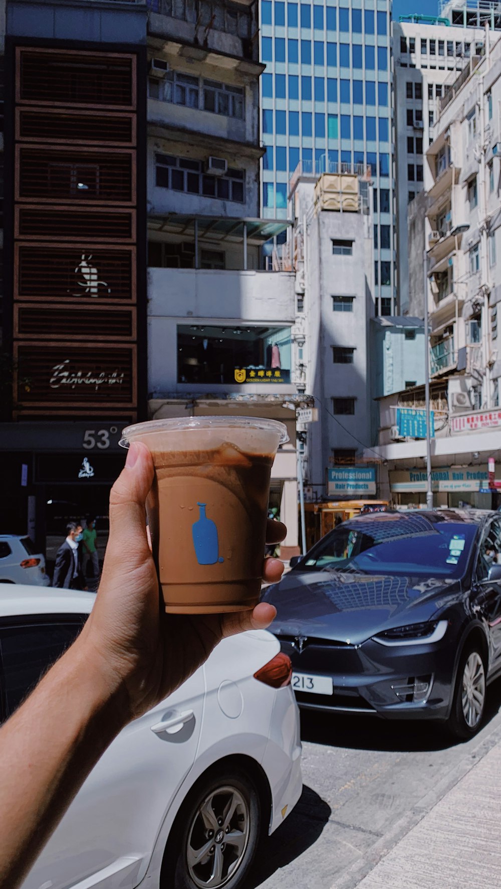 person holding brown and white disposable cup