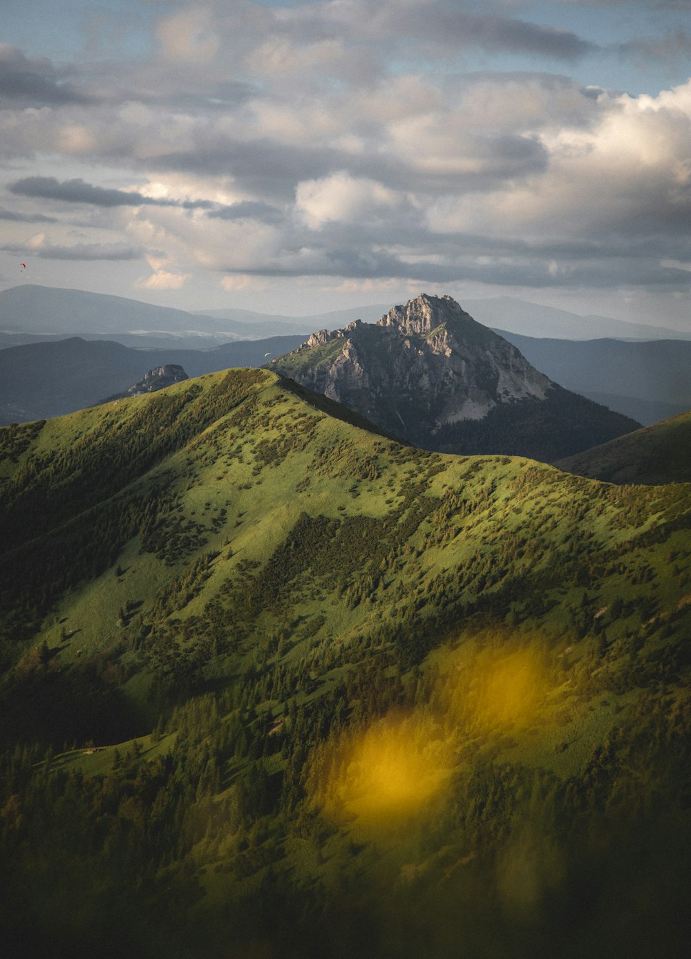 green and black mountain under white clouds during daytime