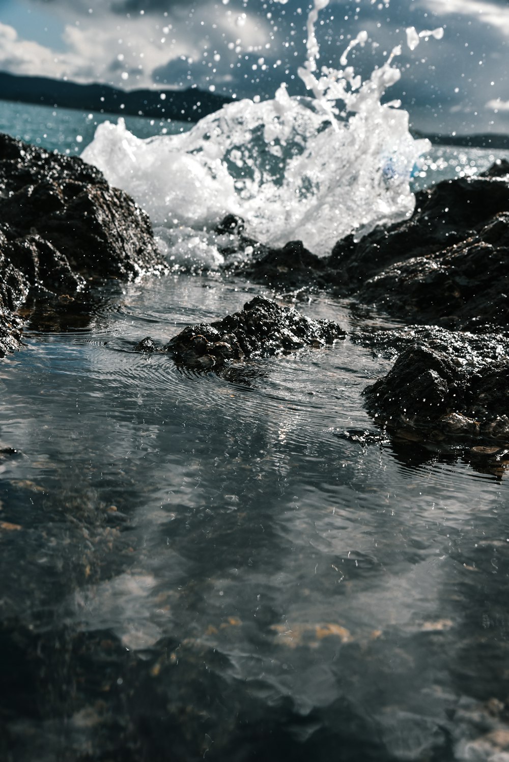 Le onde d'acqua colpiscono le rocce durante il giorno