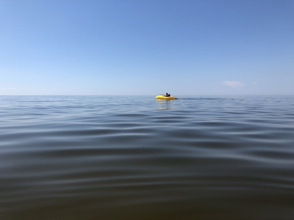 yellow and white boat on sea during daytime