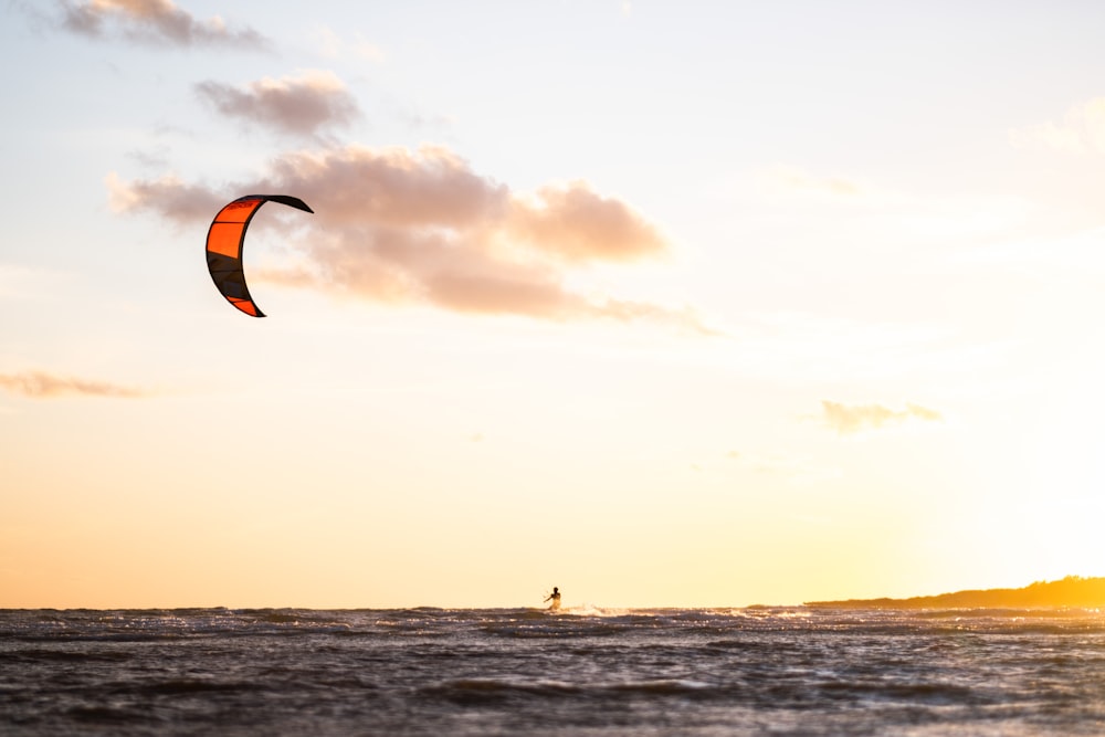 person surfing on sea during sunset