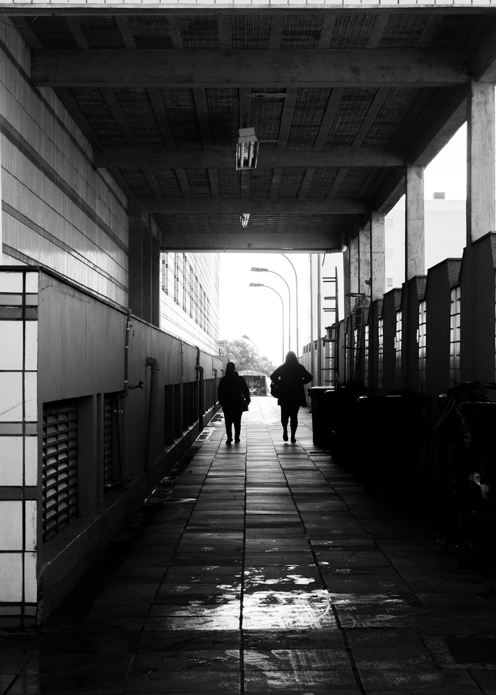 grayscale photo of people walking on train station