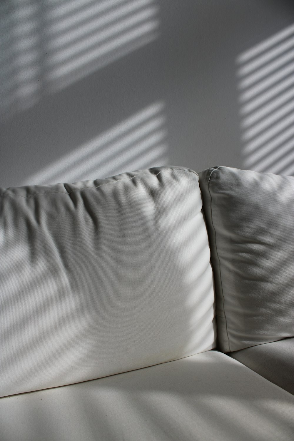 canapé en cuir blanc près du mur blanc