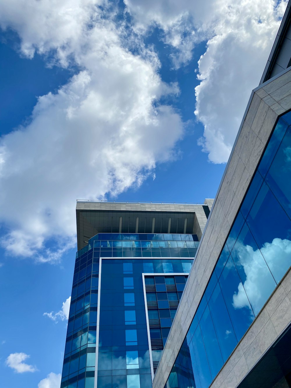 blue and white concrete building under blue sky and white clouds during daytime