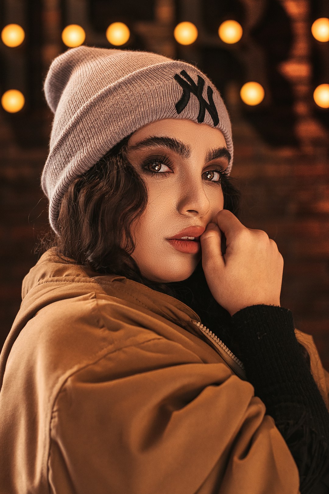 woman in brown jacket wearing black knit cap