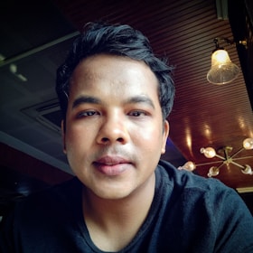 A friendly customer service representative smiling with a headset in a softly lit office.