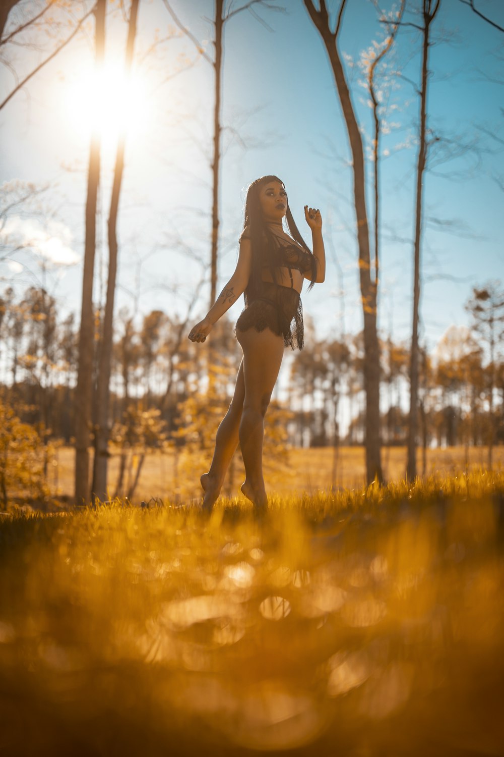 woman in black dress standing on grass field during daytime