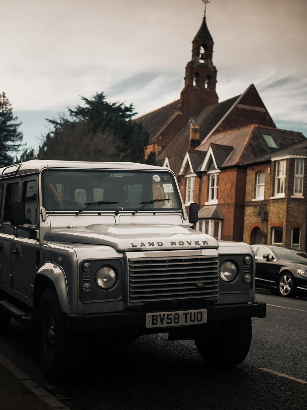 white jeep wrangler parked beside brown brick building during daytime