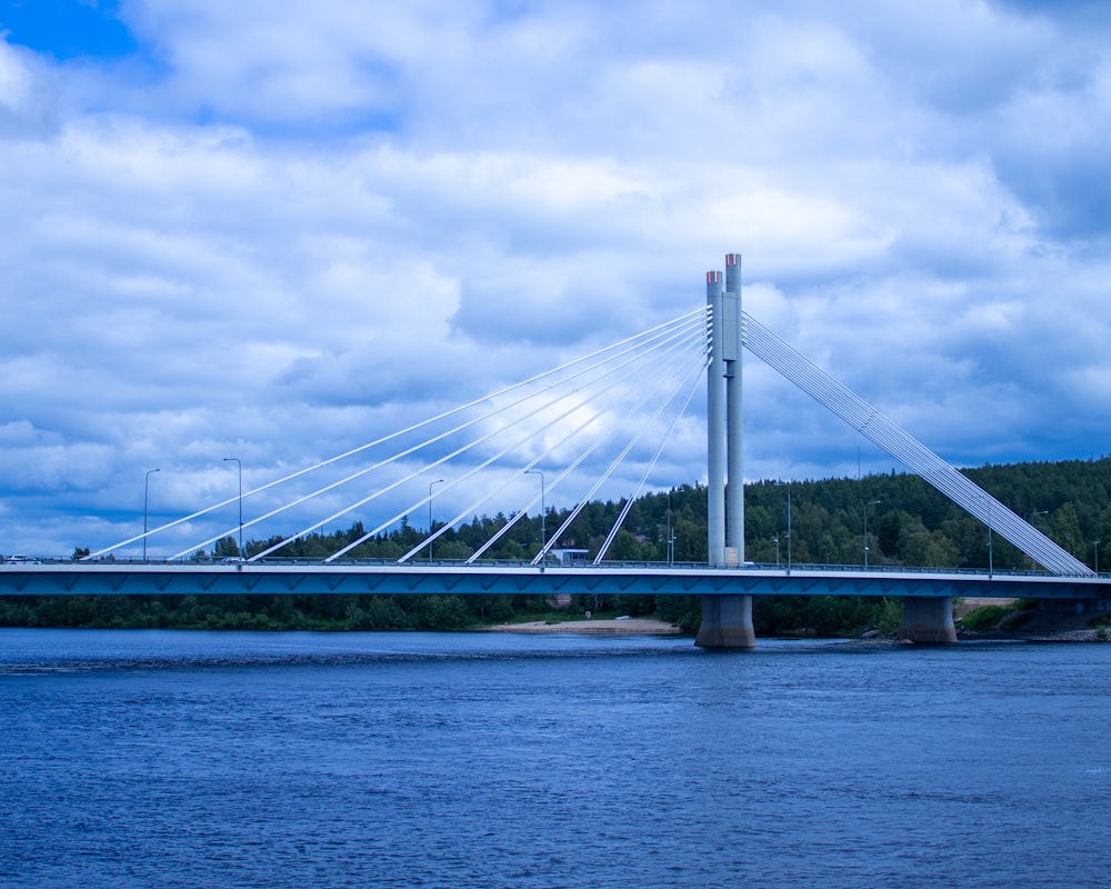white bridge over the sea under white clouds and blue sky during daytime