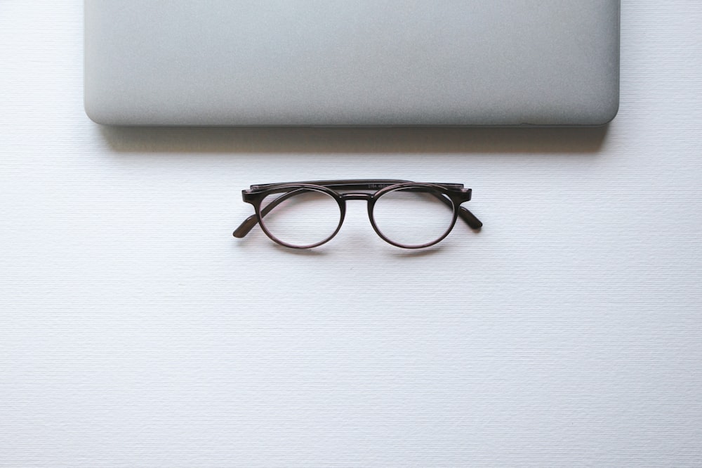 black framed eyeglasses on white table