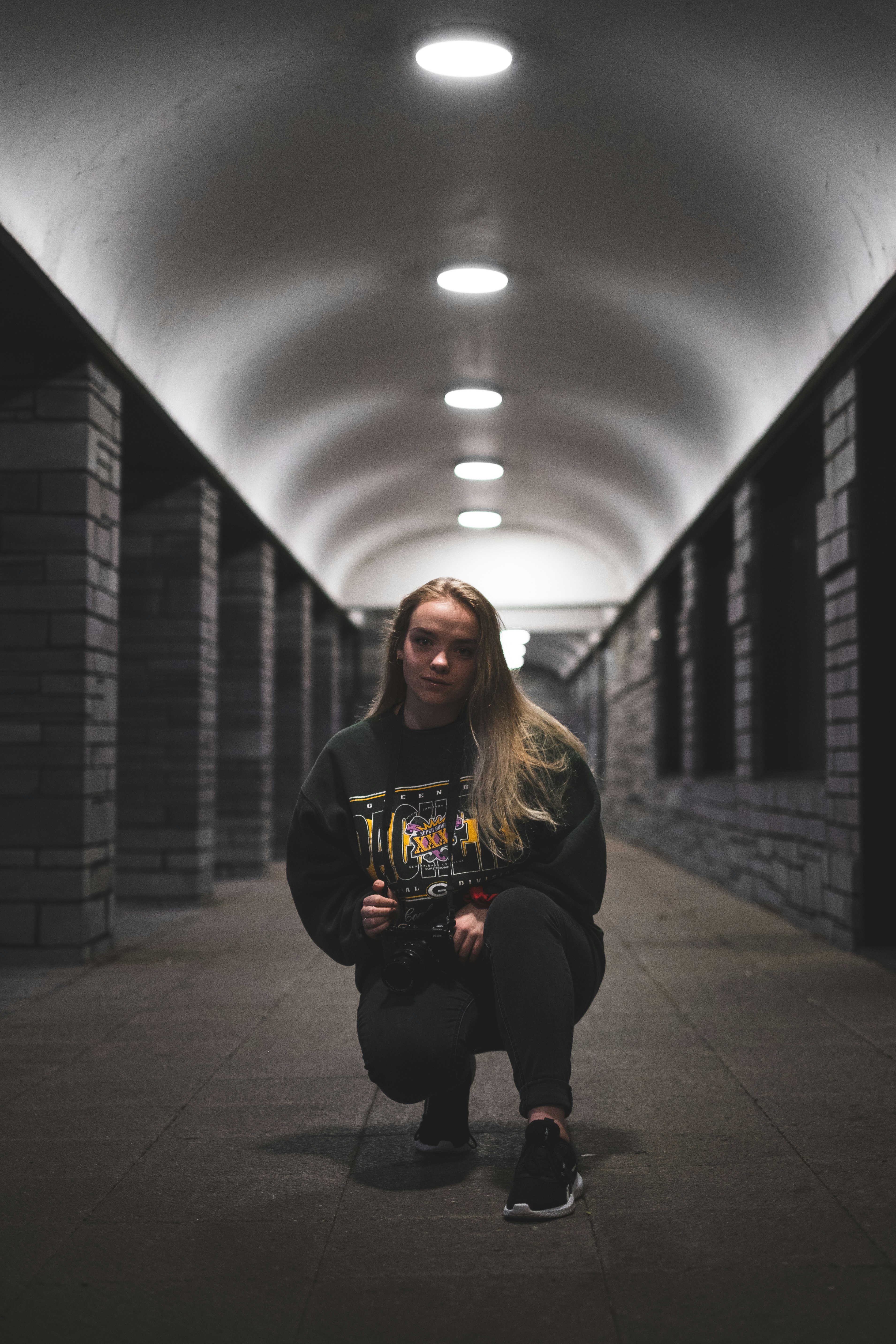 woman in black hoodie sitting on hallway