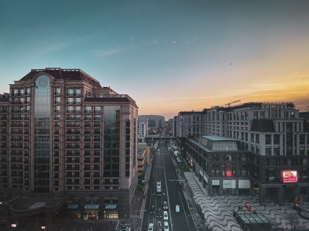 cars on road near buildings during sunset