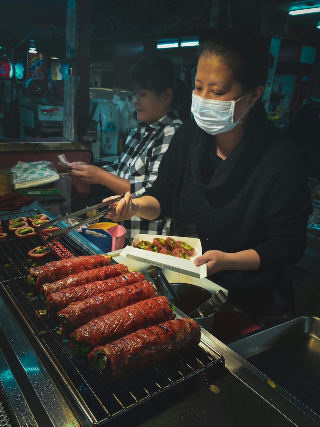 person in black long sleeve shirt holding white plastic container with meat