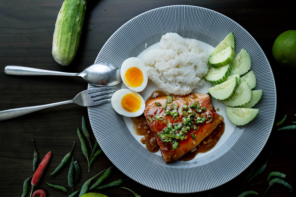 white ceramic plate with sliced cucumber and meat