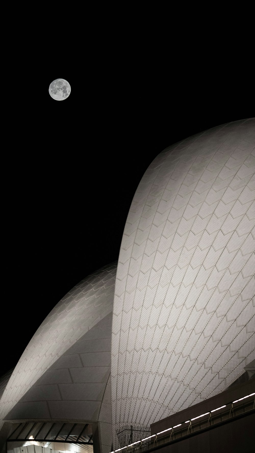 Una luna llena se ve sobre la parte superior de un edificio