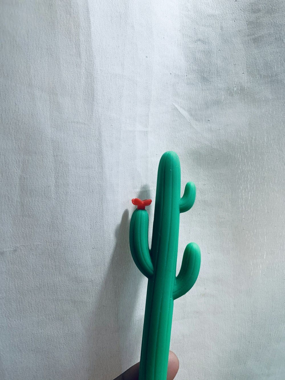 green plastic toy on white textile