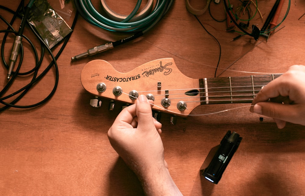 person playing brown electric guitar