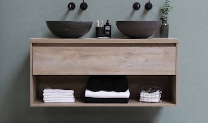 white and black ceramic bowl on brown wooden shelf