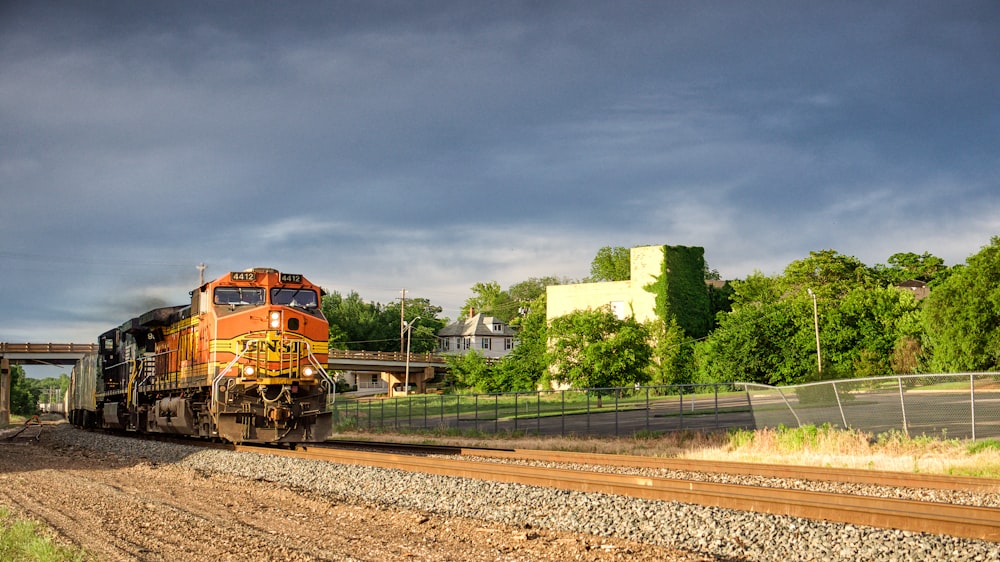 orange train on rail road during daytime