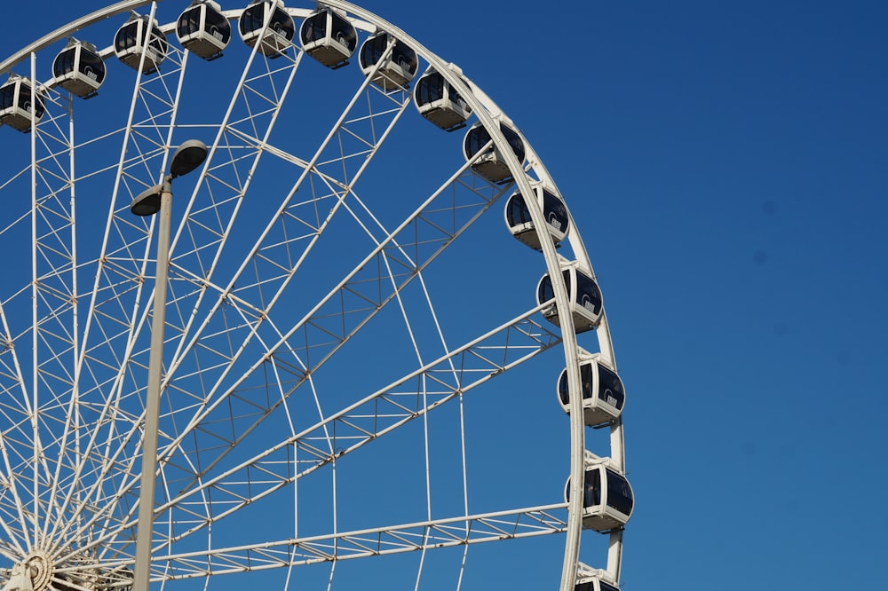 roda gigante branca e preta sob o céu azul durante o dia