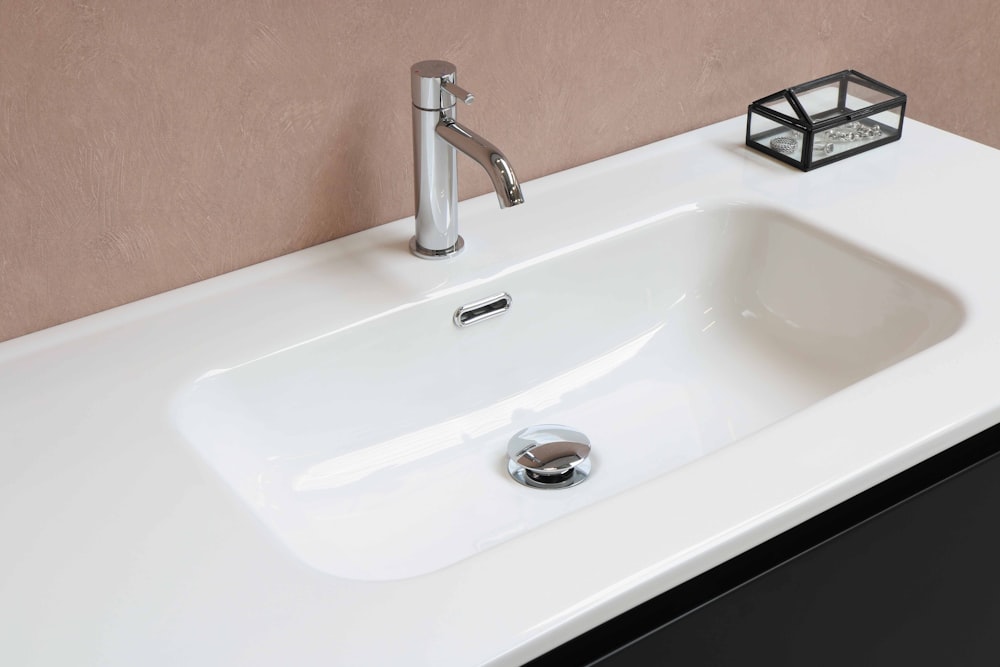 stainless steel faucet on white ceramic sink